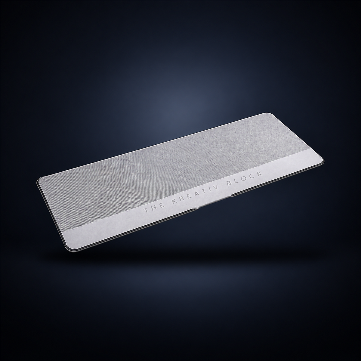 Studio concept view of a grey Block Desk Mat; the final colour and product specifications are unconfirmed.