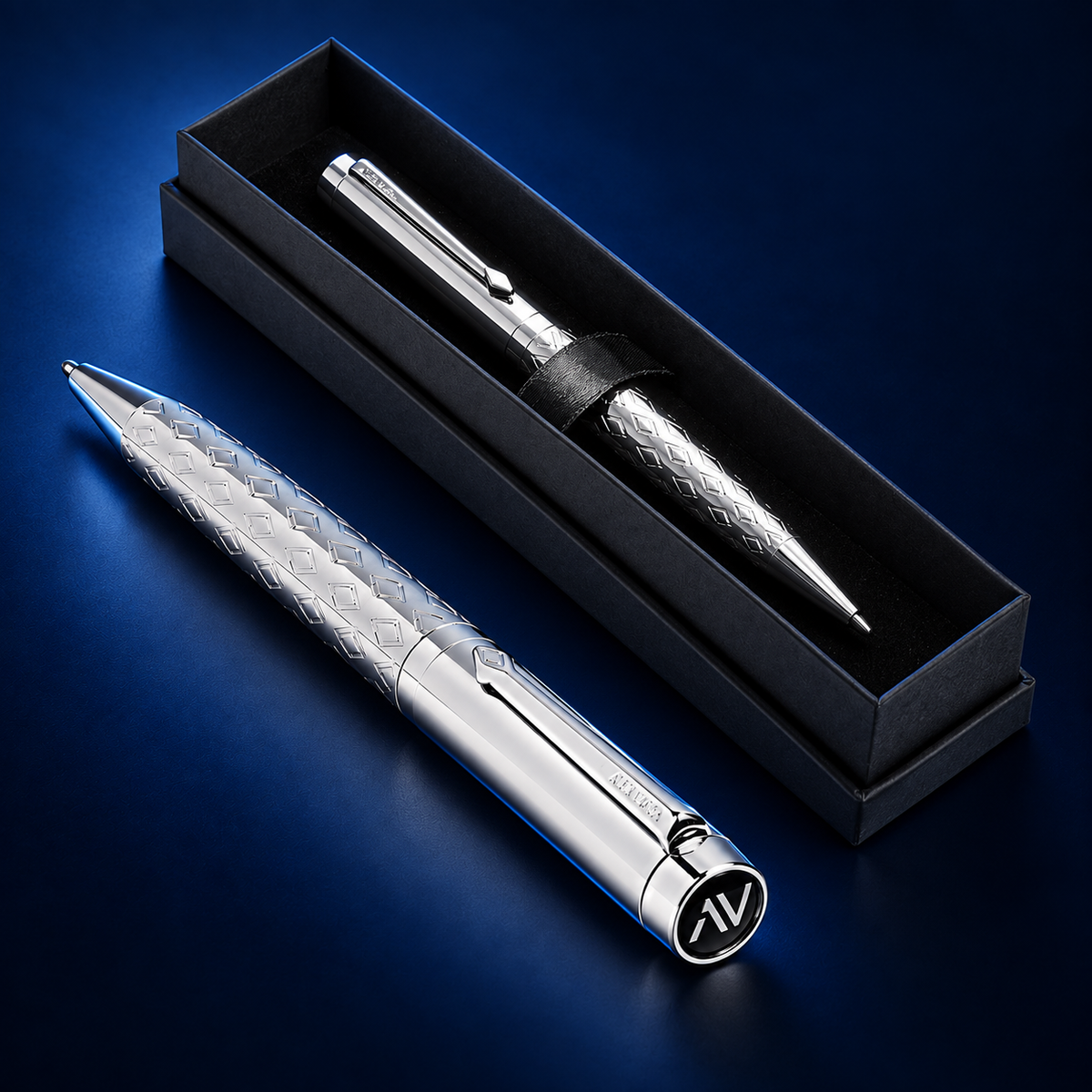 Studio product photograph of the silver Alex Varga Orion ball pen beside its black presentation box on a deep midnight navy background.